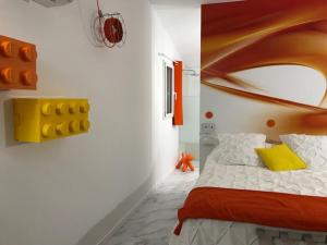 a bedroom with a bed with a yellow pillow at La Maison 1440 in LʼIsle-sur-la-Sorgue