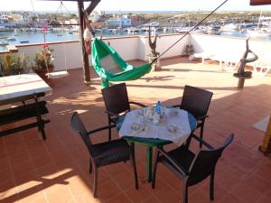 a patio with a table and chairs and a hammock at Casa appartamento in Lampedusa
