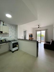 Il comprend une cuisine et un salon avec un canapé et une cuisinière. dans l'établissement Le Coin - MDJ, à Cabo Frio