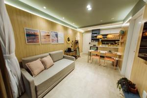a living room with a couch and a kitchen at Apartamento Beira Mar com Jacuzzi in João Pessoa