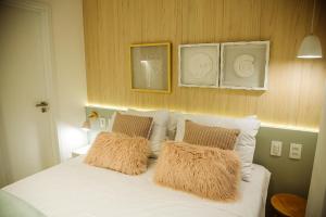 1 dormitorio con 1 cama blanca y 2 almohadas en Apartamento Beira Mar com Jacuzzi, en João Pessoa