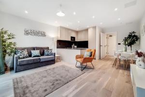 a living room with a couch and a table at Deluxe Harrow Wembley Apartment in Harrow