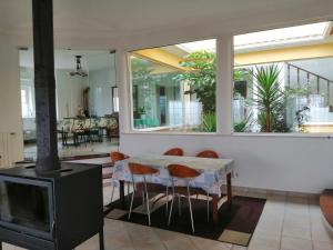 una sala da pranzo con camino, tavolo e sedie di Casa do Trovador a Serra