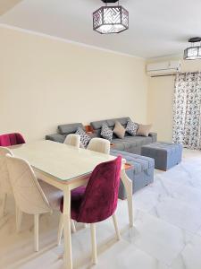un soggiorno con tavolo, sedie e divano di 2BD Apartment In New Alamein City شقة فندقية مدينة العلمين الجديدة a El Alamein