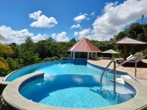a large swimming pool with a gazebo at Eden Crest Villa in Anse La Raye