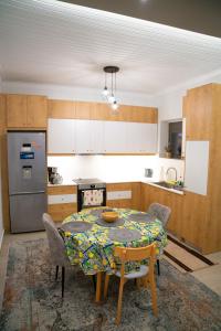 uma cozinha com uma mesa com cadeiras e um frigorífico em Όμορφη μονοκατοικία με 2 υπνοδωμάτια και τζάκι em Lepanto