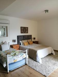 een slaapkamer met 2 bedden en een nachtkastje bij Casa do Trovador in Serra