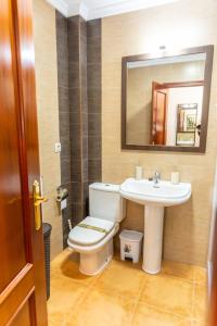 ein Badezimmer mit einem WC, einem Waschbecken und einem Spiegel in der Unterkunft Casa El Lance - Patio y Paseo Marítimo in Barbate