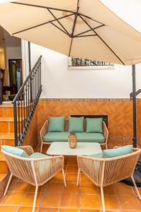 eine Terrasse mit einem Sofa, Stühlen und einem Tisch in der Unterkunft Casa El Lance - Patio y Paseo Marítimo in Barbate