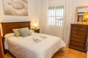 Un dormitorio con una cama con una tortuga. en Casa El Lance - Patio y Paseo Marítimo, en Barbate
