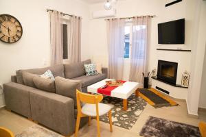 uma sala de estar com um sofá e uma mesa em Όμορφη μονοκατοικία με 2 υπνοδωμάτια και τζάκι em Lepanto