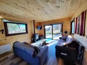 ein Wohnzimmer mit 2 Sofas in einem Blockhaus in der Unterkunft Refugio de montaña en pleno centro Malalcahuello. in Malalcahuello