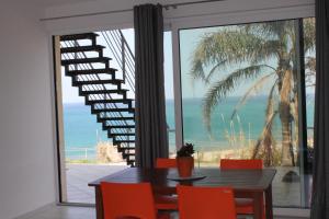 a dining room with a table and chairs and a staircase at Terrazze sul golfo apartments in Castellammare del Golfo