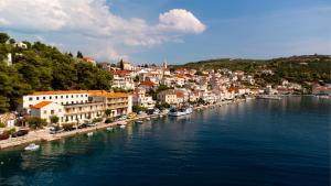 a town on a river with boats in the water at Apartmani Ada 1 in Povlja