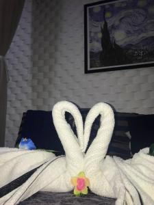 Dos cisnes hechos de toallas en una cama en Relais de Charme Boutique Hotel Pititinga, en Rio do Fogo