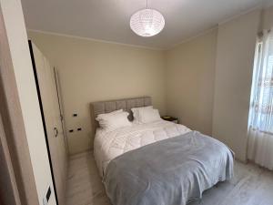 a bedroom with a bed with white sheets and a light at Apartment in Qerret in Golem