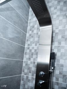 a shower in a bathroom with a tile wall at LE VIEUX LAVAL in Laval