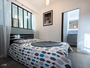 Schlafzimmer mit einem Bett mit einer schwarzen und weißen Bettdecke in der Unterkunft LE VIEUX LAVAL in Laval