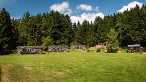 a large grassy field with houses in the background at Tayview Lodges in Dunkeld