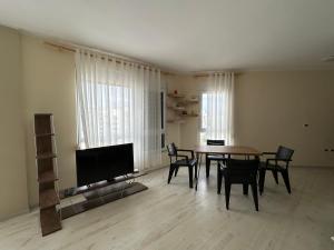a living room with a table and chairs and a television at Apartment in Qerret in Golem