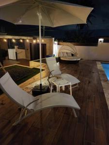 ein Zimmer mit 2 Stühlen und einem Sonnenschirm in der Unterkunft Casa Delizia close to everywhere! in San Juan