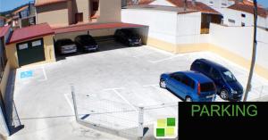 um parque de estacionamento com dois carros estacionados nele em Hotel Portonovo no Portonovo
