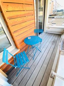 twee blauwe stoelen en een tafel op een veranda bij Large Studio in Center with Terrace. 1 min walk to the Tram. Cosy in Luxemburg