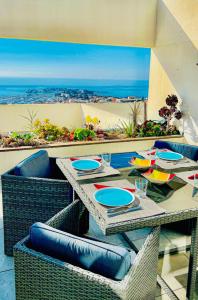 un tavolo e sedie su un balcone con vista sull'oceano di MAGNIFIQUE APPARTEMENT T4 GRAND STANDING - VUE MER PANORAMIQUE ET PISCINE a Bandol