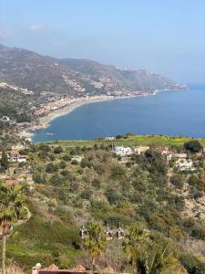 einen Blick auf den Strand und eine Wasserfläche in der Unterkunft DIMORA DISIU - Jacuzzi & Sea View - 4 minuti a piedi dal centro in Taormina