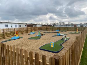 a playground with colorful play equipment in a yard at East Coast Chalets 333 Sunny Corner at California Sands in Great Yarmouth