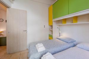 a bedroom with two beds and a green and yellow wall at Il Gattino di Sanremo - Trilocale centro e stazione del treno in Sanremo