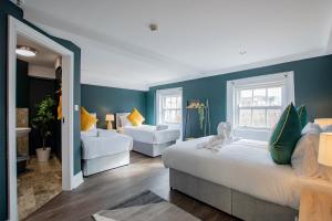 two beds in a room with blue walls at The Yellow Door by Shortstays in Dublin