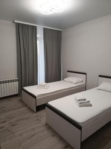 2 camas en una habitación blanca con ventana en Apartments Domovik Трьохкімнатна квартира , європейського стилю en Mukacheve