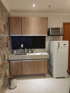 uma cozinha com armários de madeira e um frigorífico branco em Condomínio Barretos Thermas Park em Barretos