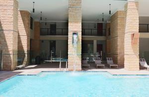 a large swimming pool in a building with columns at Private Rooftop Terrance - King Beds - Walk Score 81 & Parking 4014 in Scottsdale