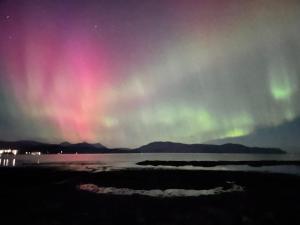 an image of the northern lights in the sky at Carnmhor, Isle of Skye - Stunning 242 year old cottage on its own sea shore! in Breakish
