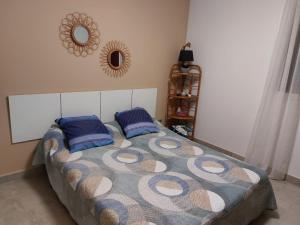 um quarto com uma cama com almofadas azuis e um espelho em Superbe appartement vue mer - résidence de standing em Schœlcher