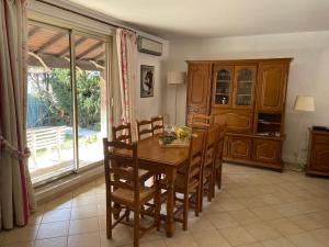 une cuisine avec une table et des chaises en bois ainsi qu'une fenêtre dans l'établissement Villa Bruyere, à Antibes