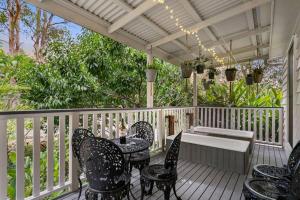 a porch with chairs and a table and a bench at Jardee Chateau Guest House in Conondale