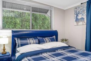 Jardee Chateau Guest House في Conondale: سرير أزرق في غرفة نوم مع نافذة