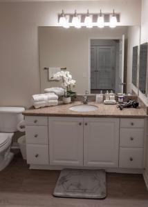 a bathroom with a sink and a large mirror at Amazing 2 bedroom 7 min from Disneyland w FREE Parking in Anaheim