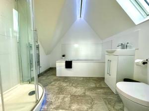 a bathroom with a shower and a toilet and a sink at Massive New 8 bedroom House Sleeps up to 21 - Accepts Groups - Great Location - FREE Parking - Fast WiFi - Smart TVs - sleeps up to 21 people - Close to Bournemouth & Poole Town Centre & Sandbanks in Bournemouth