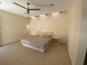 1 dormitorio con 1 cama y ventilador de techo en cocay house, en Uaymitun