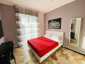 una camera da letto con un letto con una coperta rossa e uno specchio di Milano relax family house a Brugherio