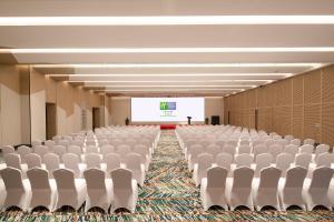 an empty room with chairs and a projection screen at Holiday Inn Resort Qionghai Guantang, an IHG Hotel in Qionghai