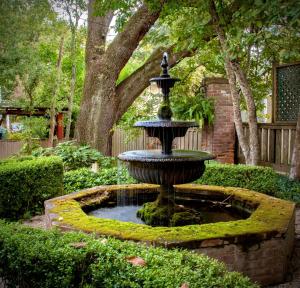 a fountain in the middle of a garden at Anchuca Historic Mansion & Inn in Vicksburg