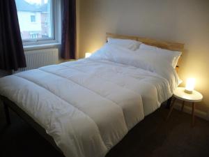 En eller flere senge i et værelse på Bright spacious home, enclosed garden & parking
