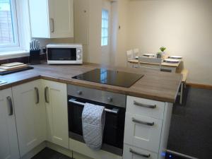 a kitchen with a sink and a microwave at Bright spacious home, enclosed garden & parking in Hindlip