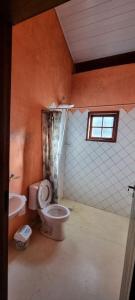 łazienka z toaletą, umywalką i oknem w obiekcie Sítio das Águas w mieście Bom Jesus dos Perdões