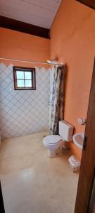 łazienka z toaletą, umywalką i oknem w obiekcie Sítio das Águas w mieście Bom Jesus dos Perdões